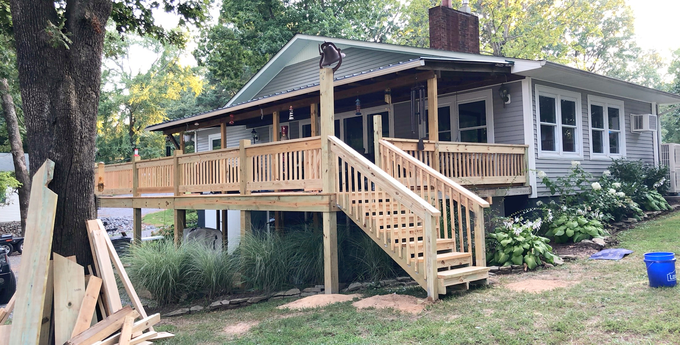 Elevated rear deck with a stair landing at a wooded lake house